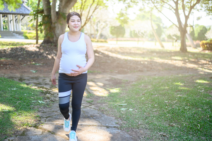 Gravid kvinne på spasertur i parken.